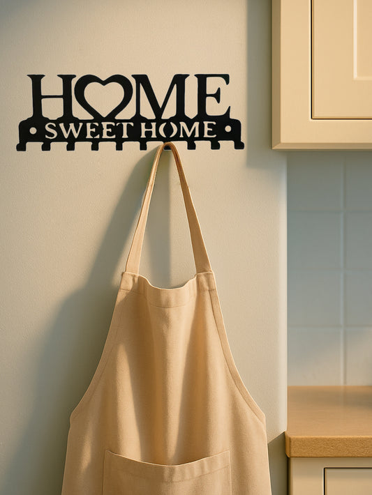 Beige apron hanging on a 'Home Sweet Home' wall decoration in a kitchen.