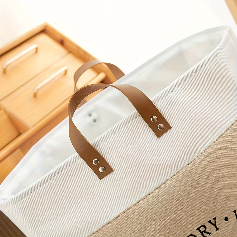 Beige tote bag with brown leather handle on a wooden surface