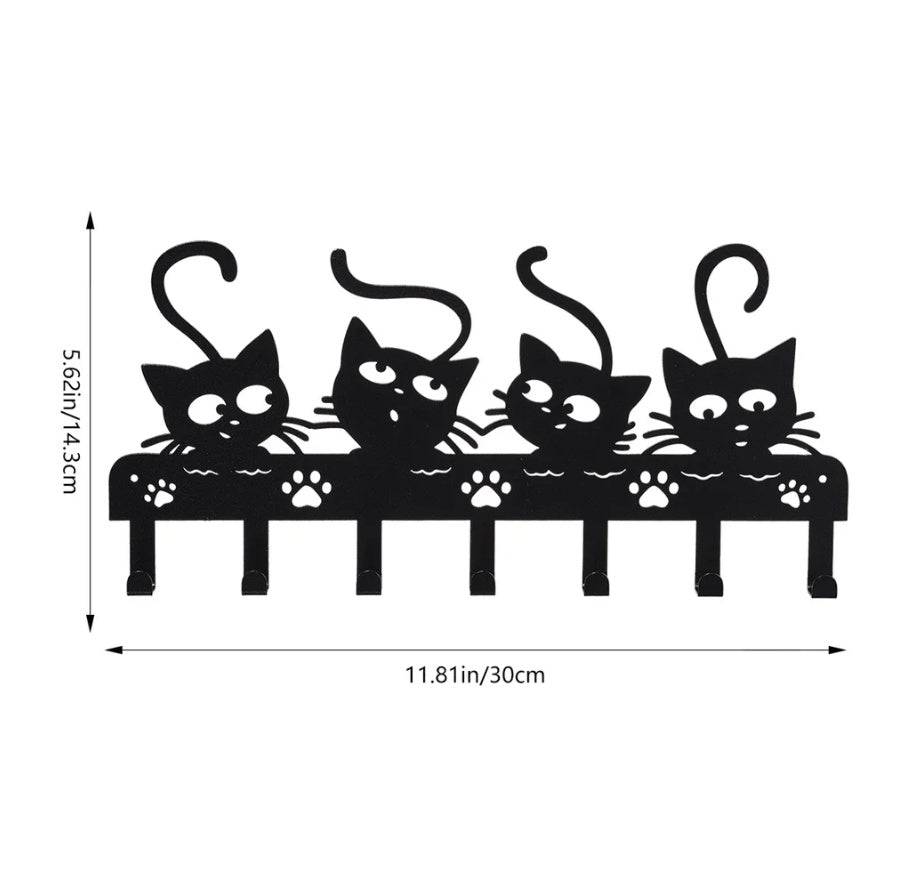 Black metal wall art of four cats sitting on a bench with dimensions indicated.