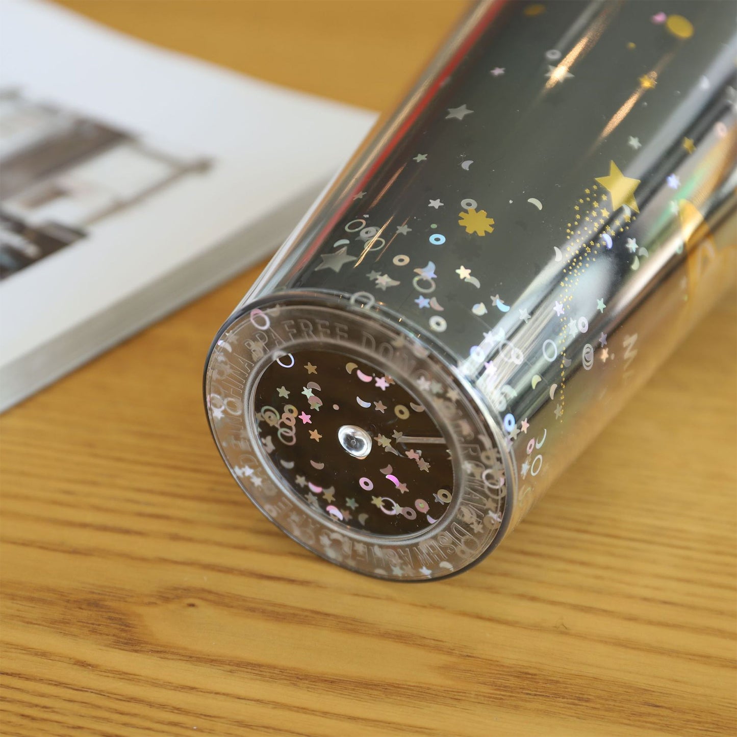 Decorative pen with star and moon designs on a wooden surface