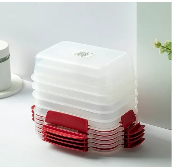 Stack of white plastic containers with red lids on a light surface.