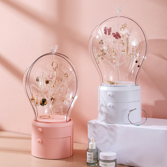 Two decorative jewelry stands with transparent domes on a pink background
